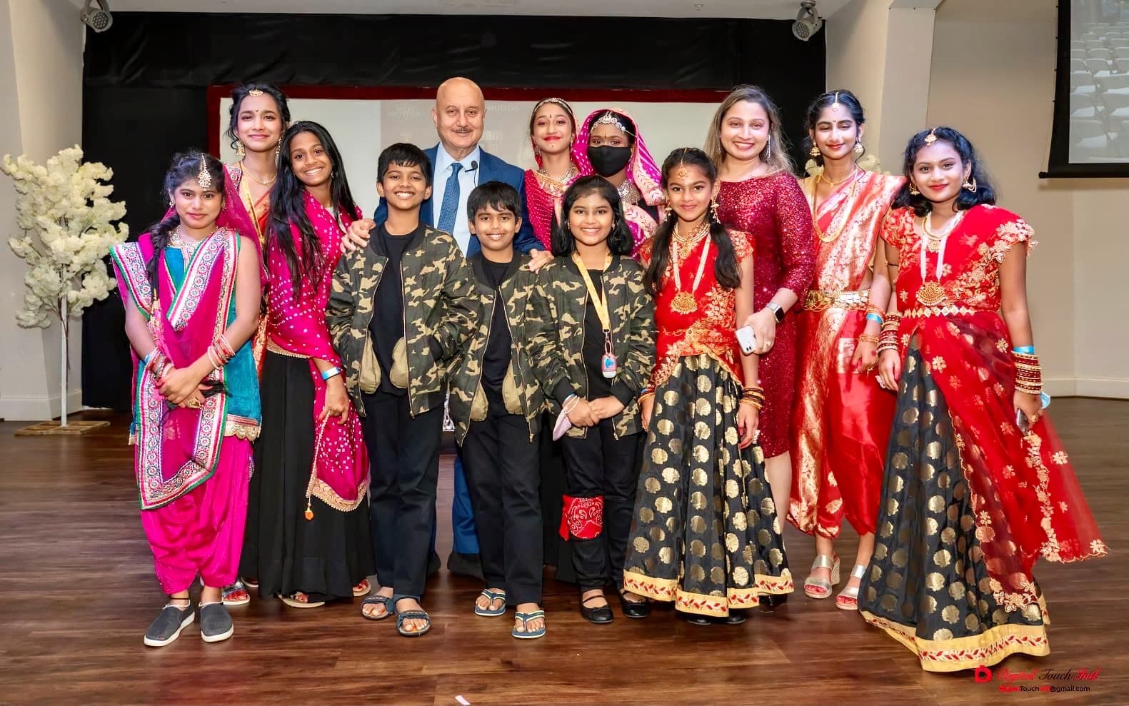 Garima Dance Academy students with a celebrity guest after a performance, posed as a group on stage