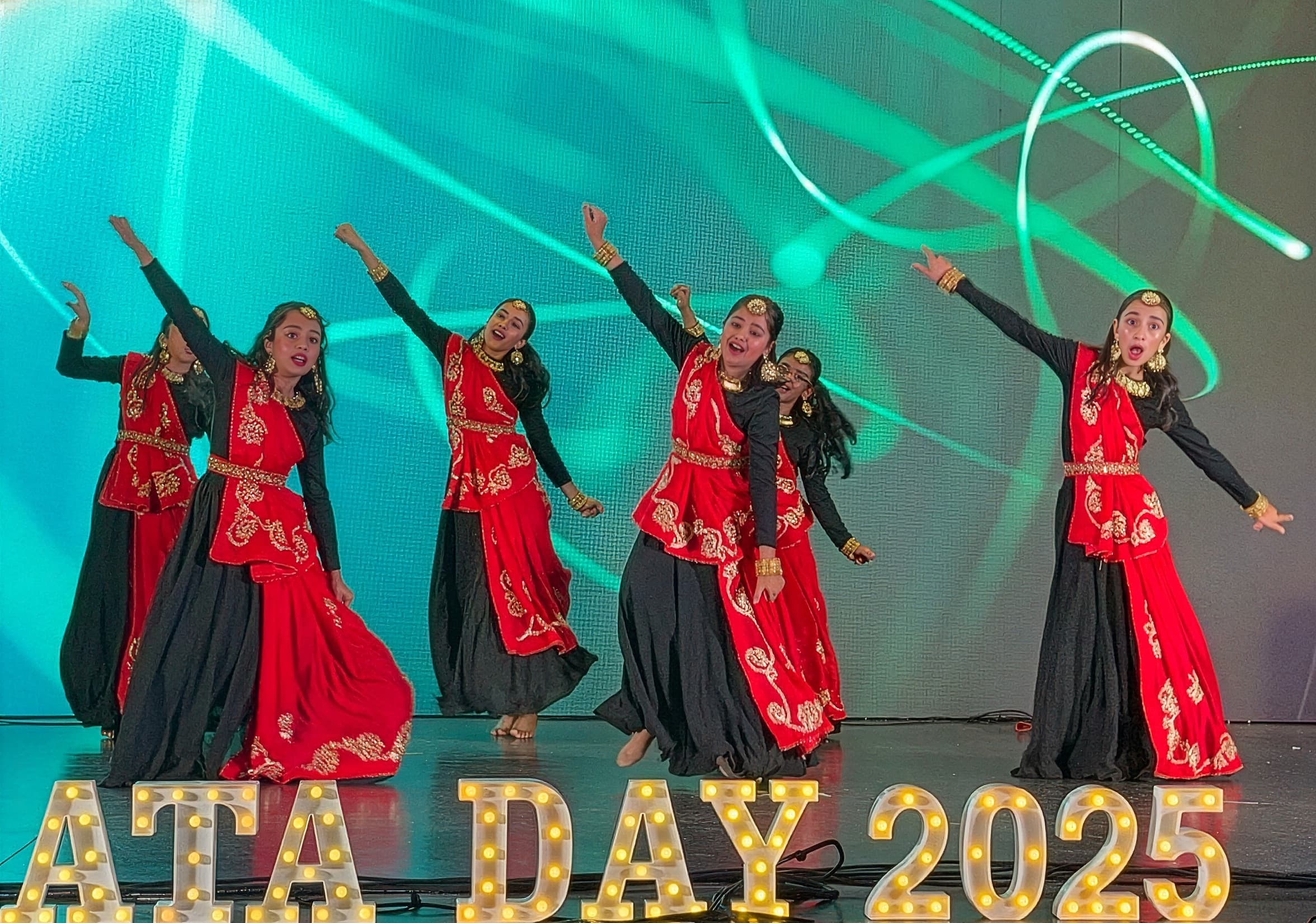 Garima Dance Academy students in red and black Bollywood costumes mid-performance on the ATA Day 2025 stage